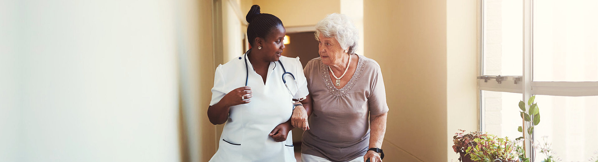 nurse and senior woman talking while walking